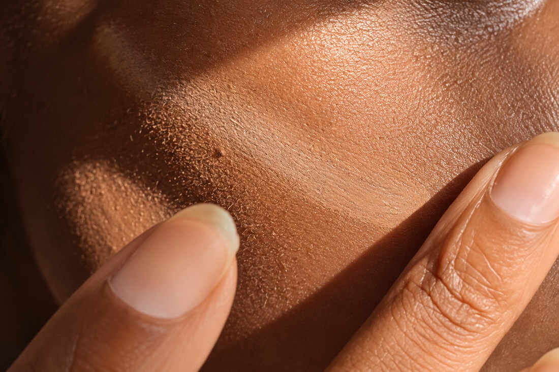 Application du fond de teint Fusion Opposée au doigt sur une peau foncée au grain naturel