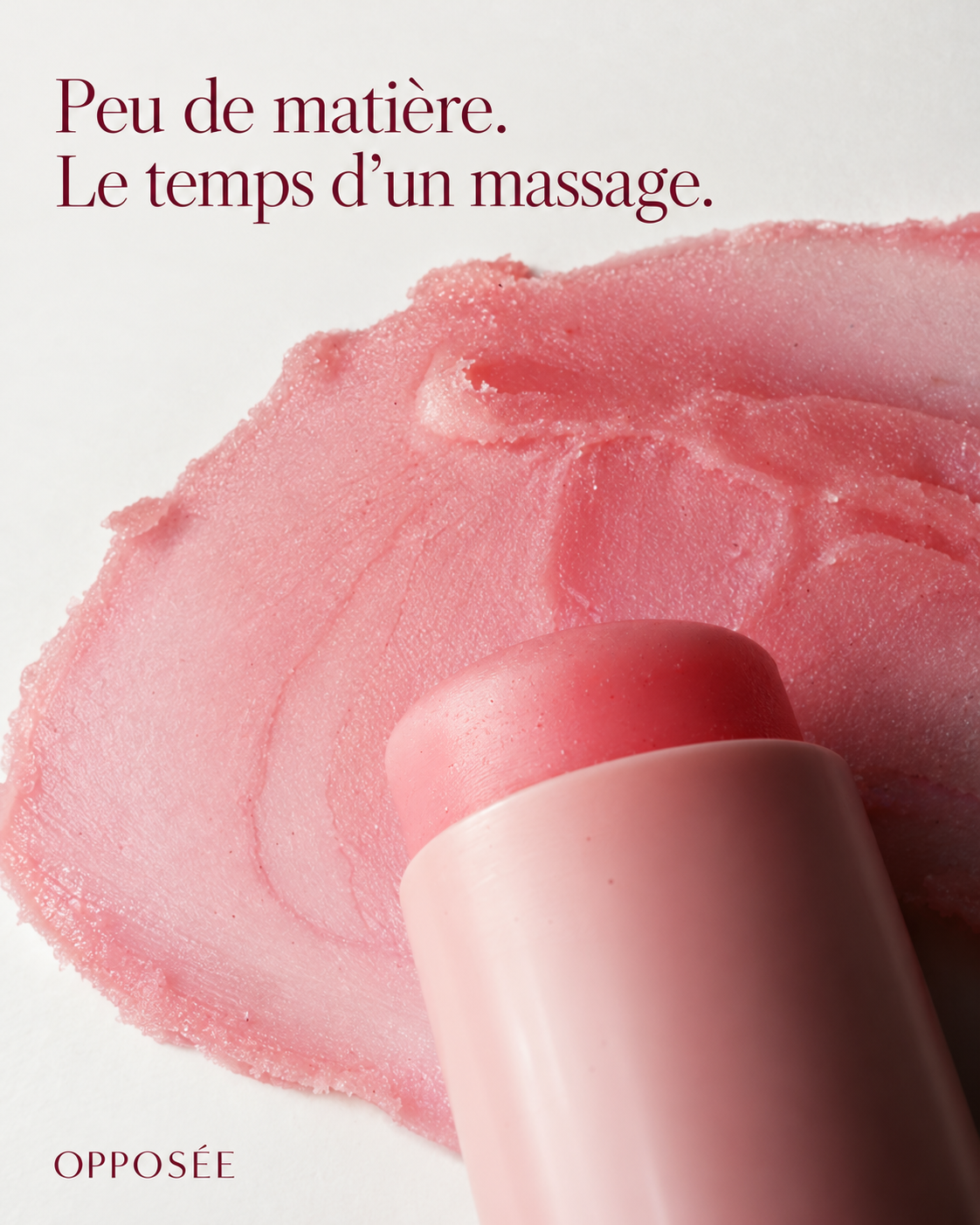 Gros plan du stick et de la texture rose saumon de Nomade Opposée. Texte : « Peu de matière. Le temps d’un massage. »