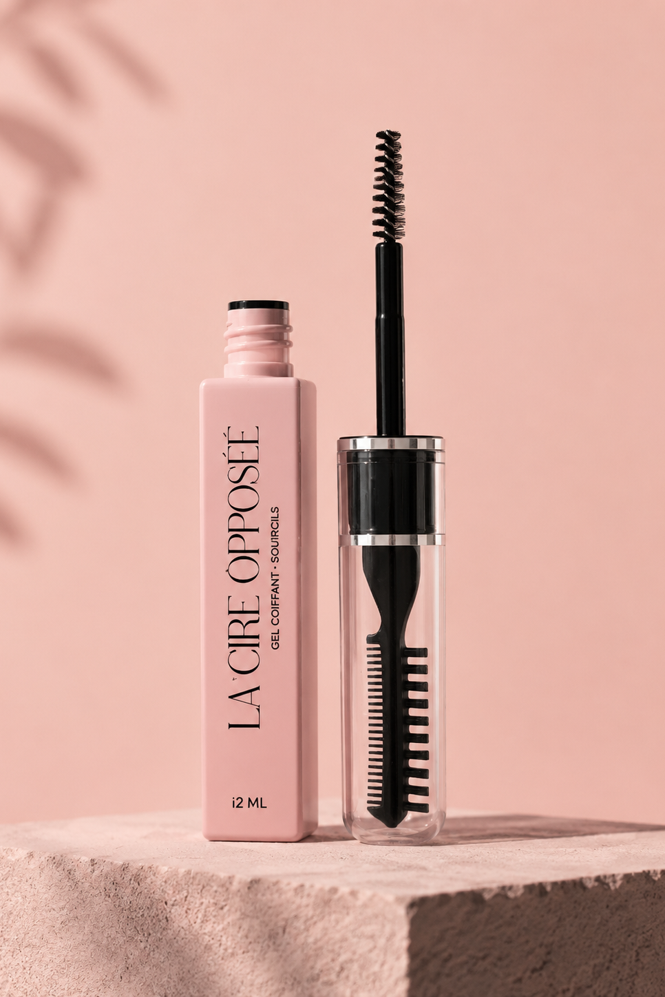La Cire Opposée, gel coiffant pour sourcils avec brosse applicatrice, sur fond rose poudré.