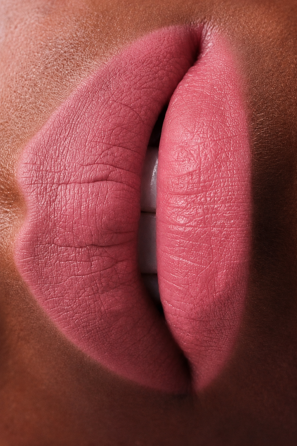 Teinte rose du rouge à lèvres Le Velours Opposée portée sur une peau foncée