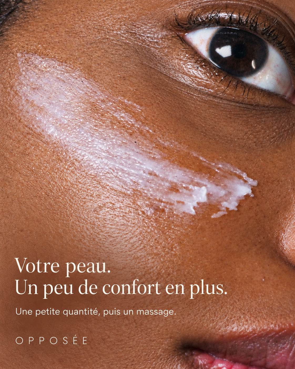Gros plan de la texture de Nomade Opposée déposée sur une joue avant massage. Texte : « Votre peau. Un peu de confort en plus. Une petite quantité, puis un massage. »
