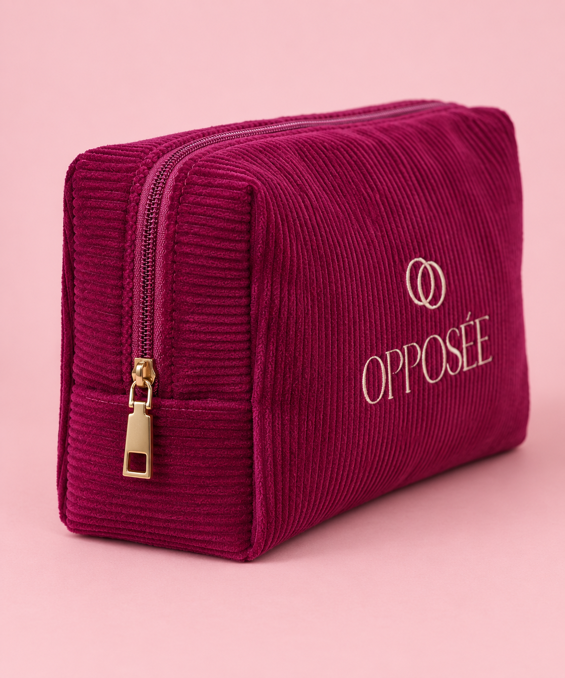 Vue latérale de la trousse de maquillage Opposée en velours côtelé bordeaux avec fermeture dorée.